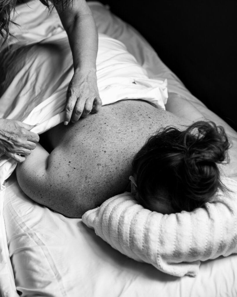 A woman receiving a massage in a relaxing setting at The Village social club in San Antonio.