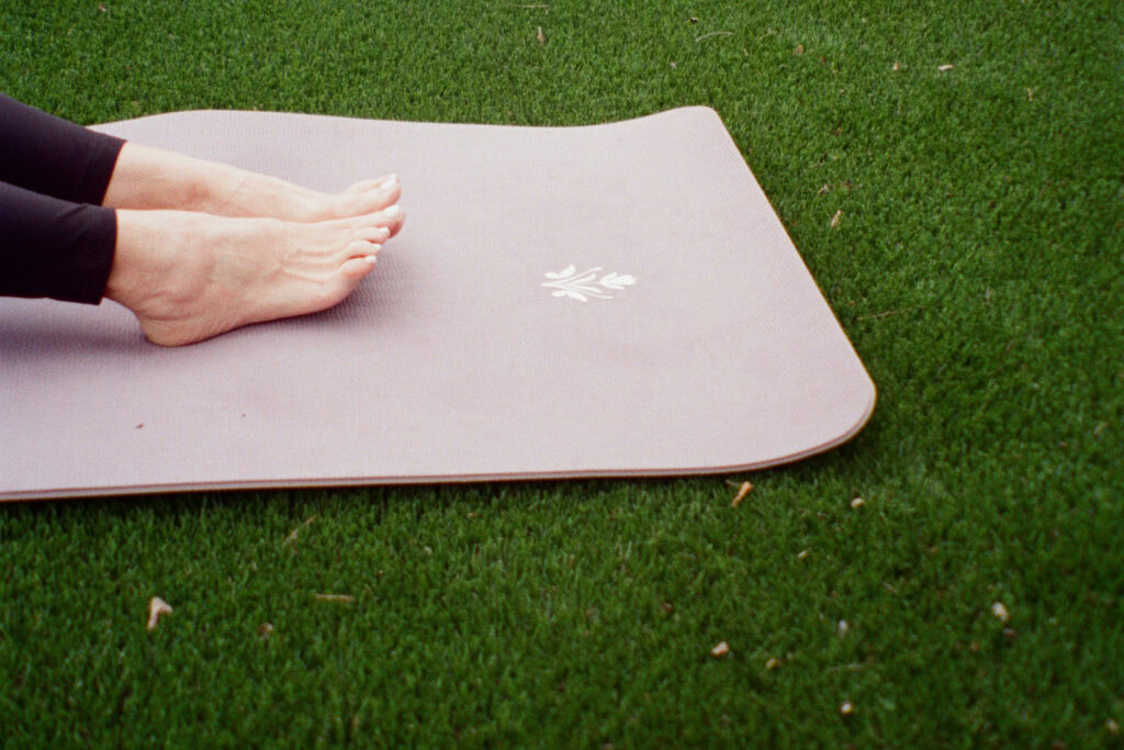 A person practicing yoga on a mat in The Village community in San Antonio.