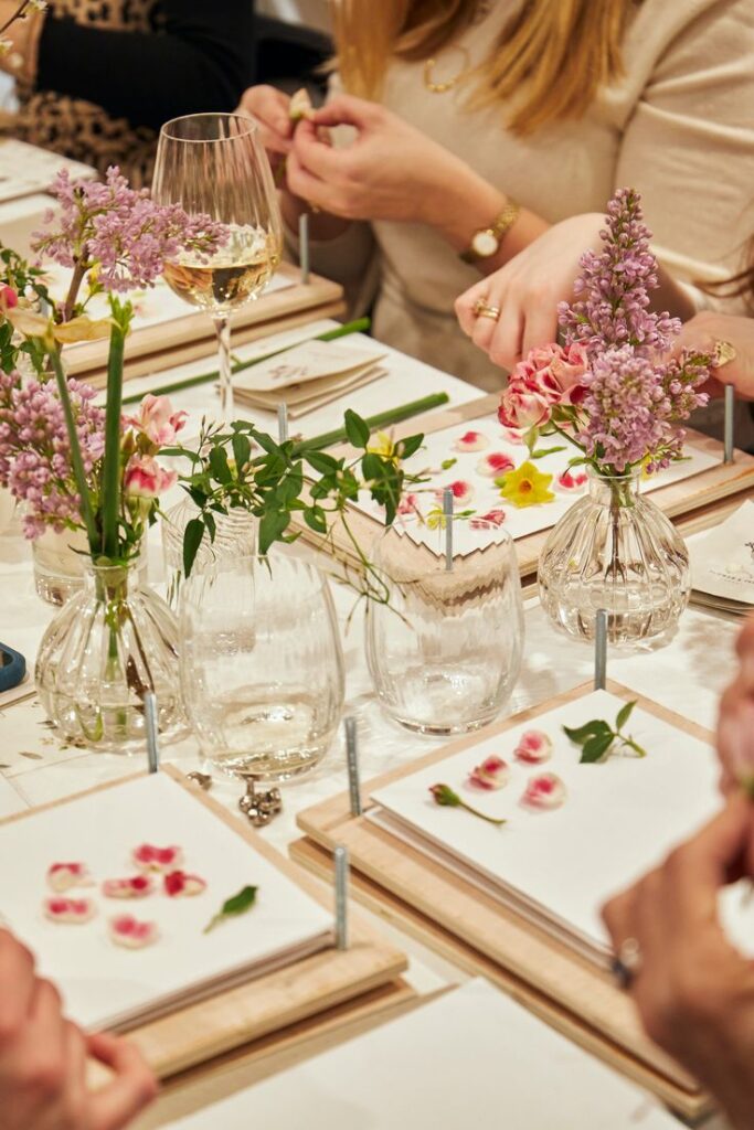Women at The Village social club enjoying a community event with flowers and wine in San Antonio.