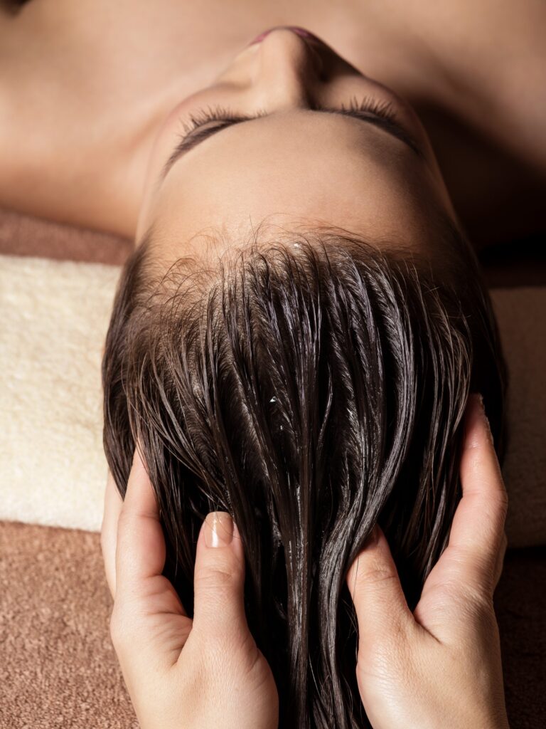 A woman getting a scalp massage at The Village social club in San Antonio.
